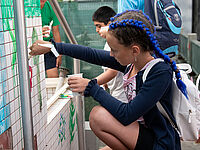 Schülerin bemalt Wände im Papageienschutzzentrum