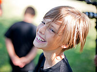 Sport Lachendes Kind auf einer Wiese