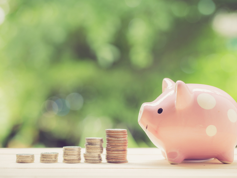 Ein Sparschwein vor dem Münzen stehen