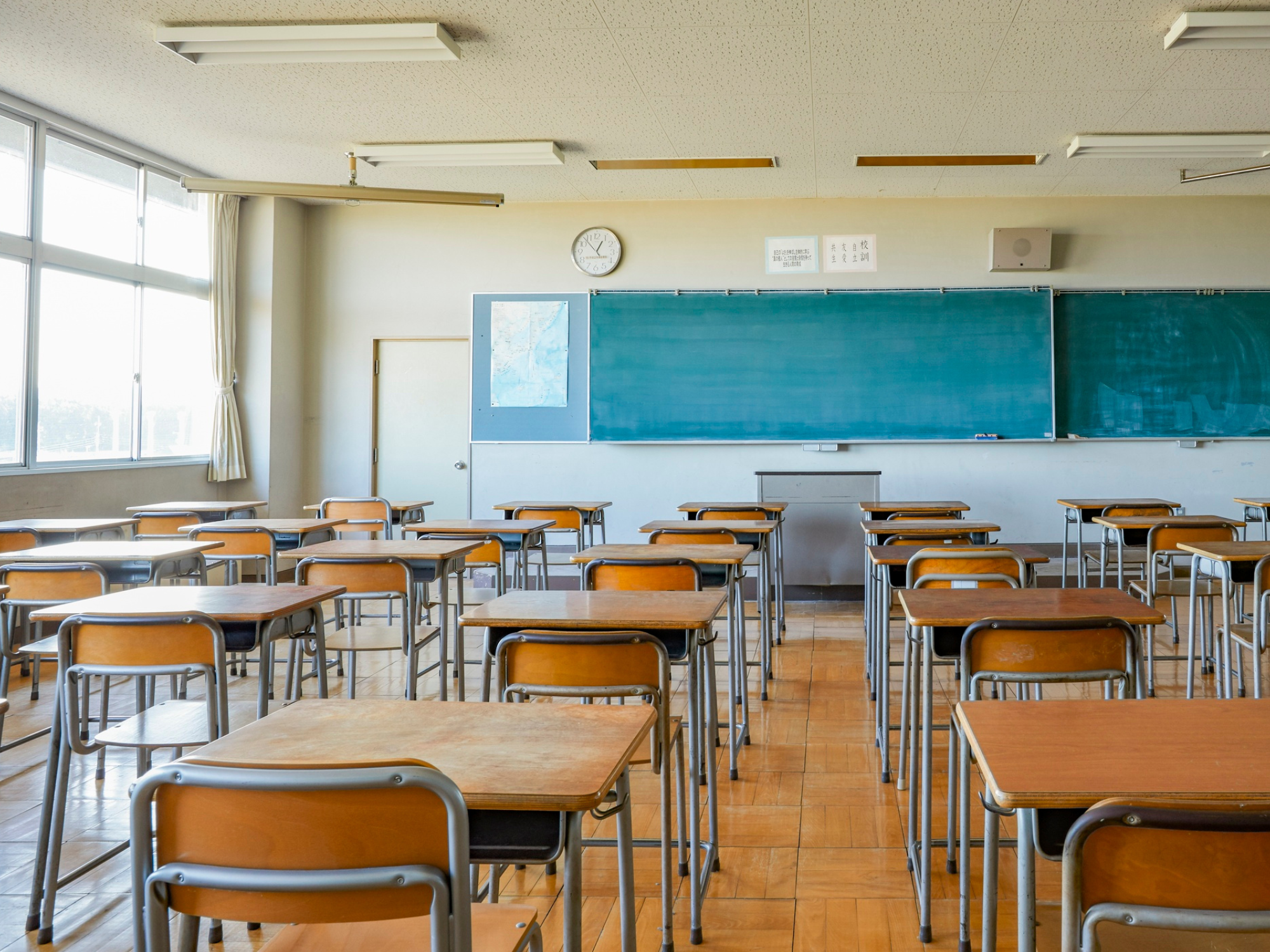 Schulklassenraum von hinten mit einer grünen Tafel vorne