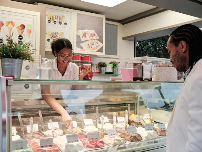 Eine Person verkauft einer anderen Person Eis beim Eisstand