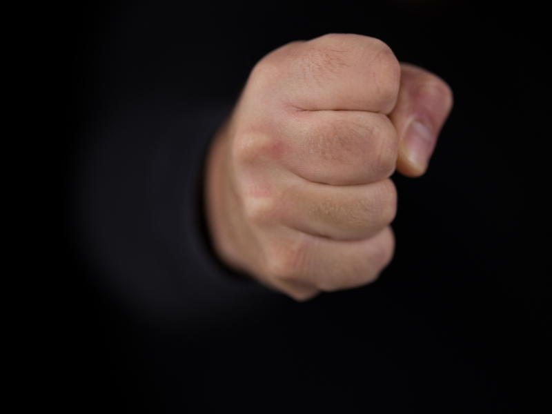 eine geballte Faust vor schwarzem Hintergrund 