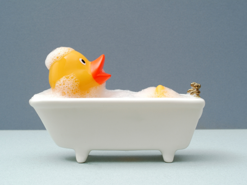 Eine Badeente in einer kleinen Badewanne mit Schaum
