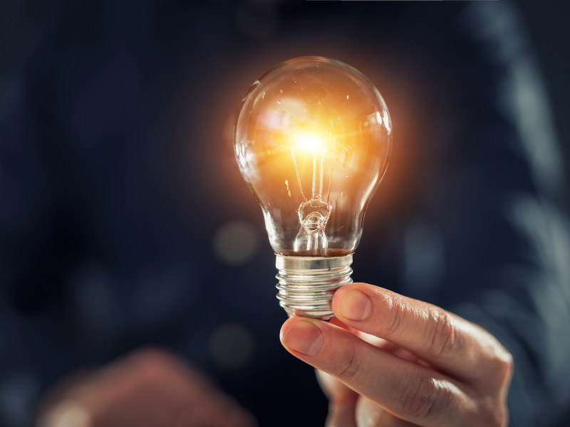 Eine Person hält eine Glühbirne