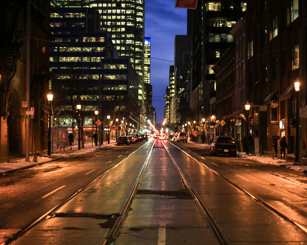 Eine Stadt per Nacht - in der Mitte sieht man Straßenbahngleise 