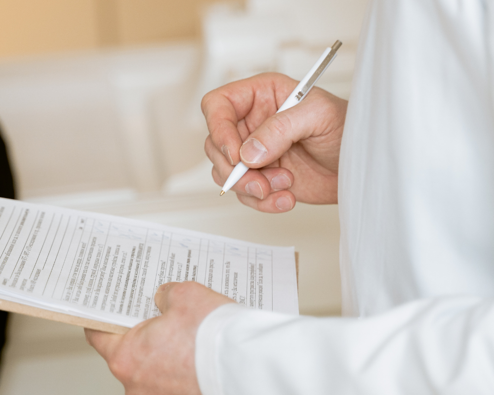 Ein*e Ärzt*in füllt ein Formular aus 