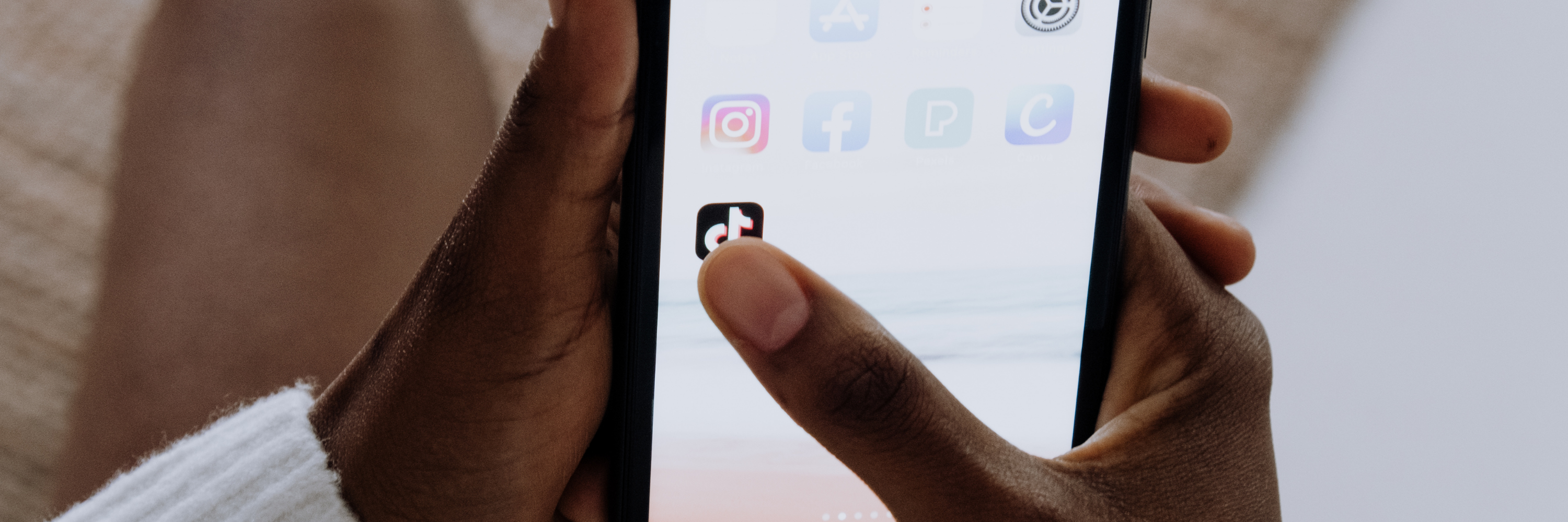 eine Person öffnet Tik Tok auf ihrem Handy 