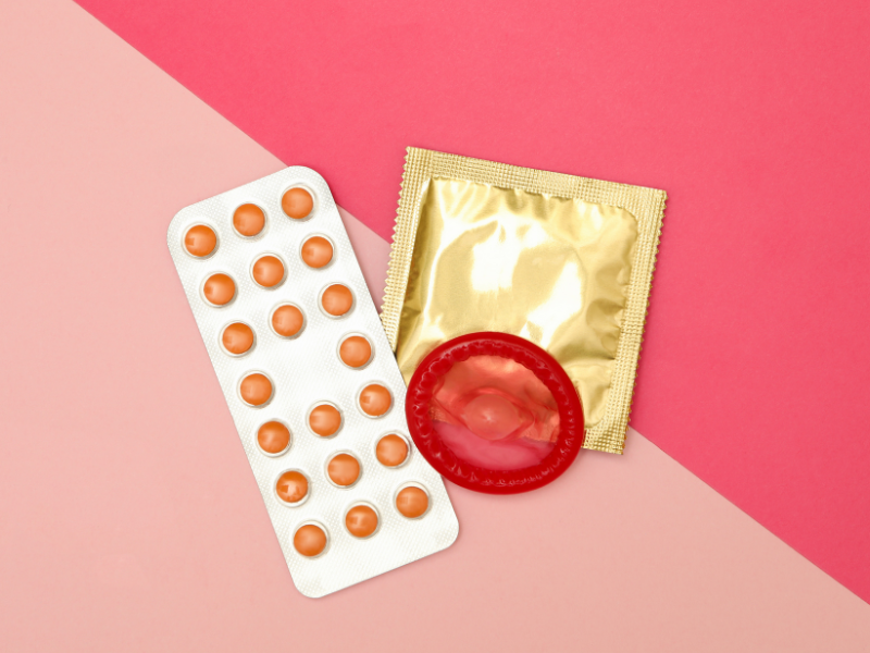 eine Hand reicht einer anderen Hand ein Kondom 