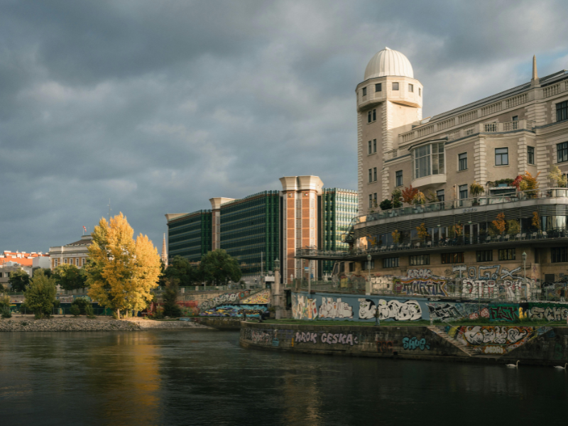 Urania-Gebäude in Wien am Donaukanal bei bewölktem Himmel.