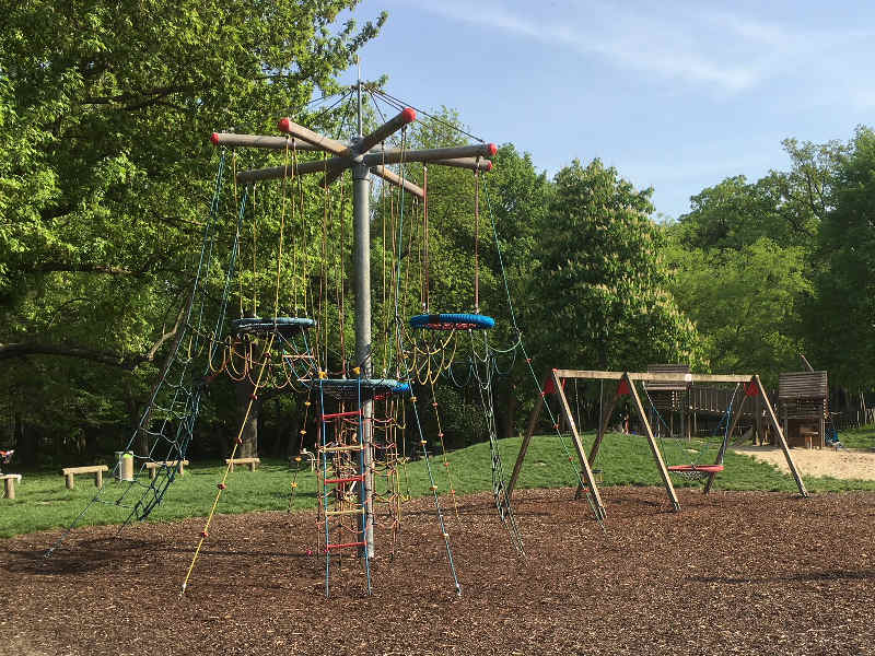 Spielplatz mit Vogelnestbaum (Kletterturm mit Nestschaukeln) sowie einer Kleinkind- und Netzschaukel.