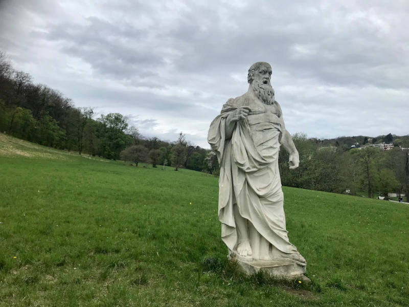 Park, in der Mitte der Wiese steht eine Attikafigur (Bass).