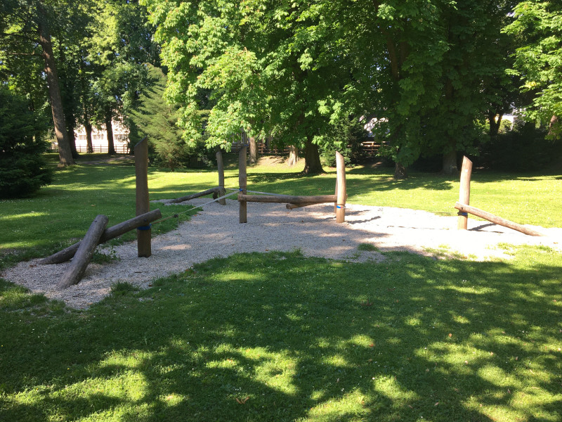 Park in St- Pölten Hammerpark, zu sehen ist eine Spiellandschaft aus Holz zum Balancieren, das Wetter ist sonnig und schön