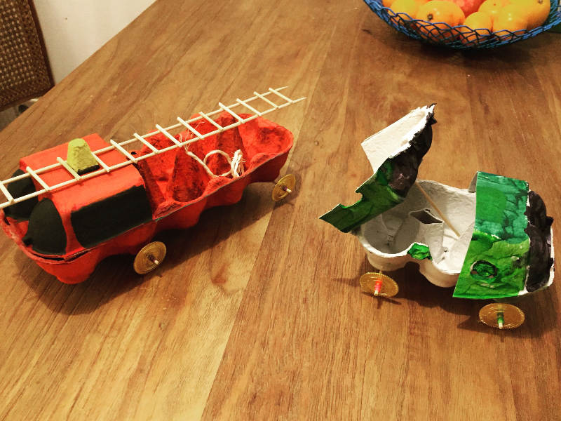Feuerwehrauto und grünes Auto aus Eierkartons.