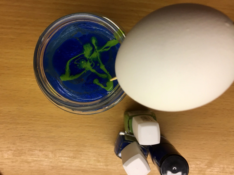 Auf dem Bild sieht man ein Ei, das zum Marmorieren bereit ist. 