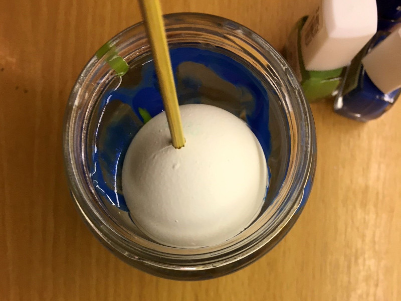 In dem Bild sieht man wie ein ei in ein Marmorierbecken eingetaucht wird