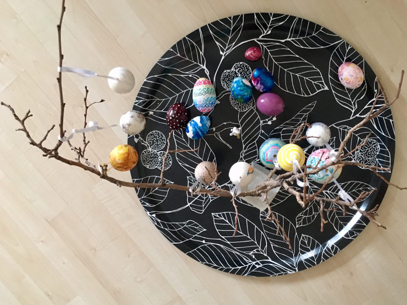 Auf dem Bild sieht man einen Strauch, der mit bunten Ostereiern behängt ist