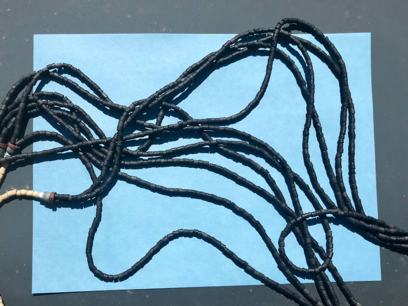 Hellblaue Papier auf dem eine mehr-reihige Kette liegt