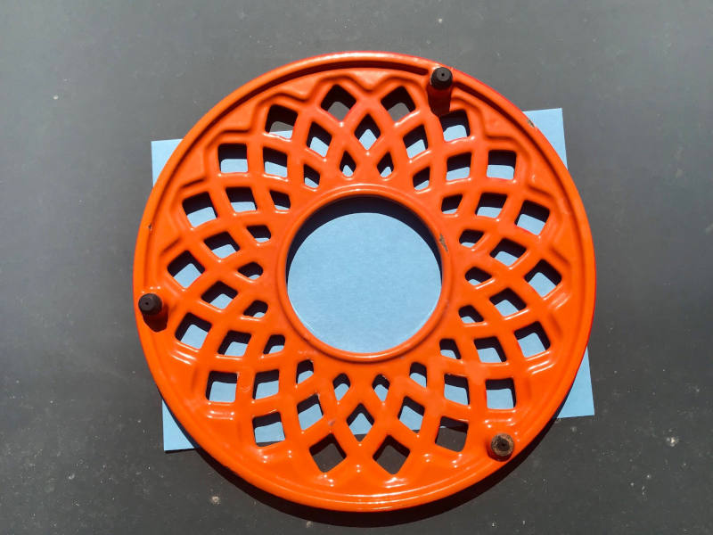 auf einem hellblauen Solarpapier liegt ein oranger Untersetzer mit Lochmuster