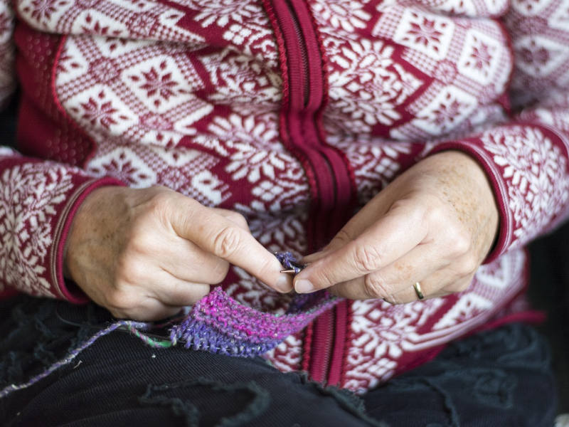 Nahaufnahme von älteren Händen die stricken.