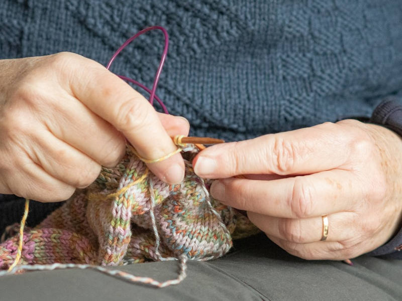 Nahaufnahme von älteren Händen die stricken.