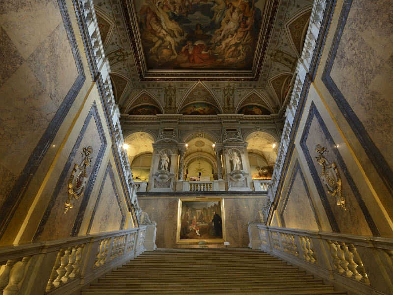 Stiegenaufgang im Naturhistorischen Museum aus Marmor, mit prunkvollen Verzierungen, Statuen und Malereien. 