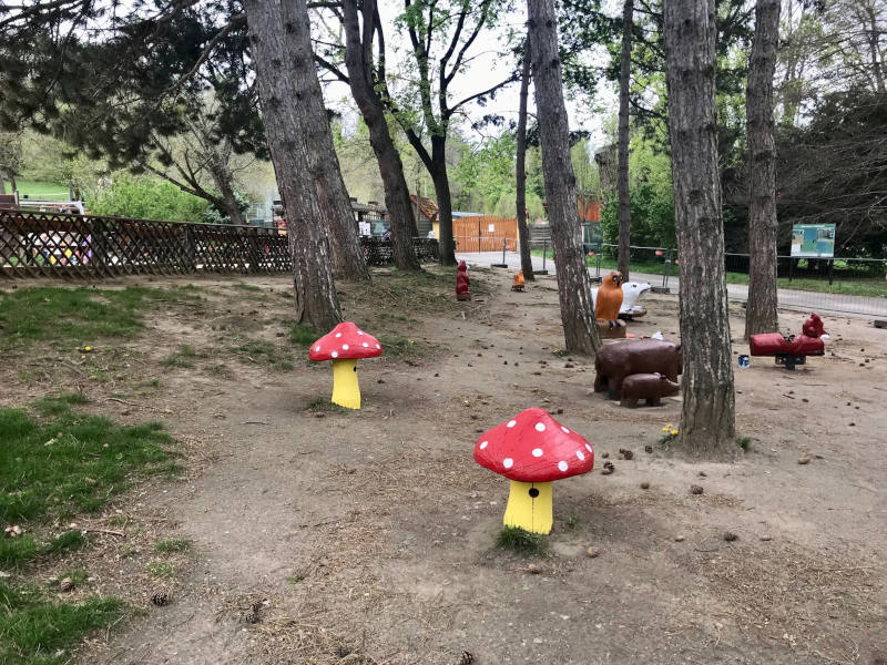 Pötzleinsdorfer Schloßpark Tiere und Pilze aus Holz unter Bäumen