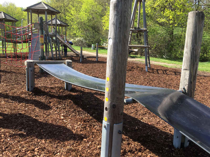 Kletteranlage mit breitem Balancierband im Vordergrund und Kletterturm im Hintergrund am  am Spielplatz Roter Berg West