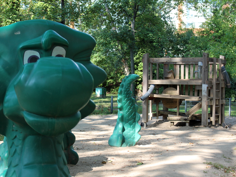 Dinoausaurierfigur die aus dem Boden ragt