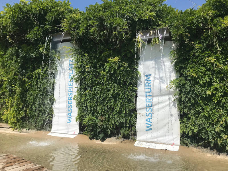 Banner am Wasserspielplatz Wand mit Efeu über die zwei strahlend weiße Banner mit dem Wortlaut Wasserturm hinunterfallen