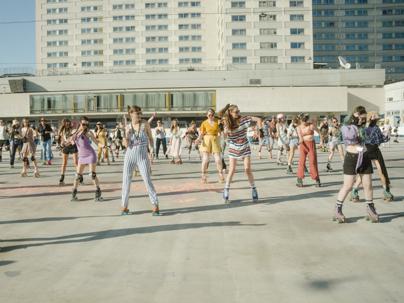 Mehrere Menschen auf Rollerskates und Tanzen auf einer großen Fläche