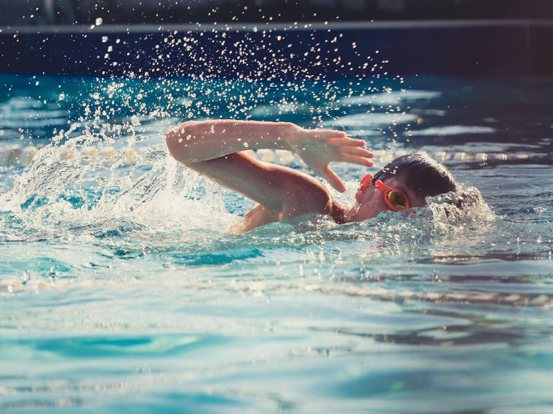 Junge tut Brustschwimmen im Wasser