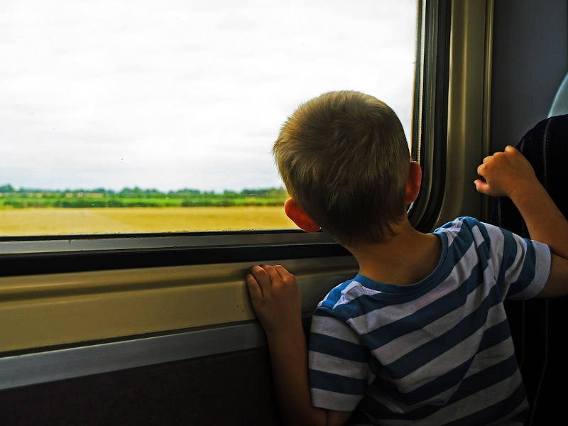 Kind schaut aus Zugfenster raus