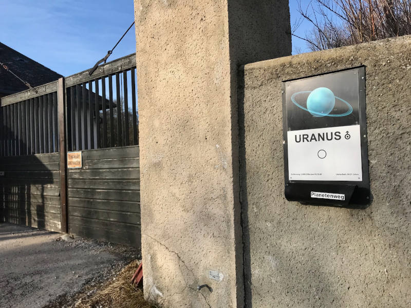 Tafel mit Bild von Uranus und Beschreibungstext auf einem Torbogen im Lainzer Tiergarten
