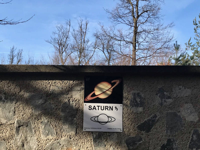 Steinmauer mit einer Abbildung von Saturn.