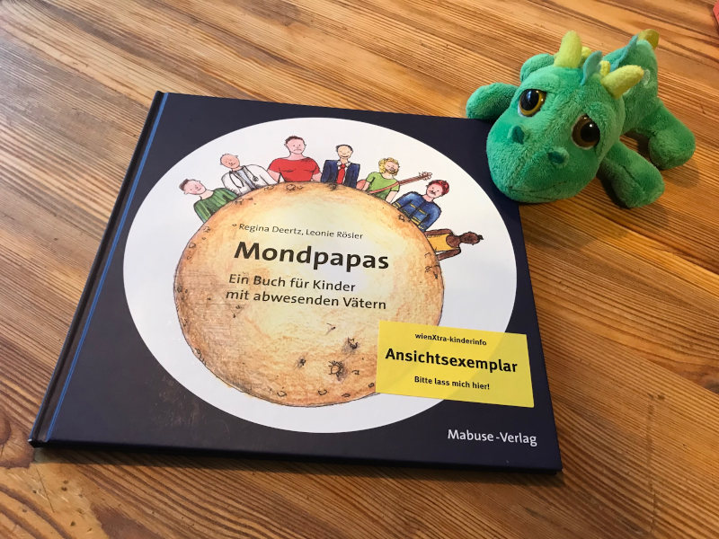 Ein Plüschdrache und ein Buchcover: Mondpapas von Regina Deertz und Leonie Rösler.