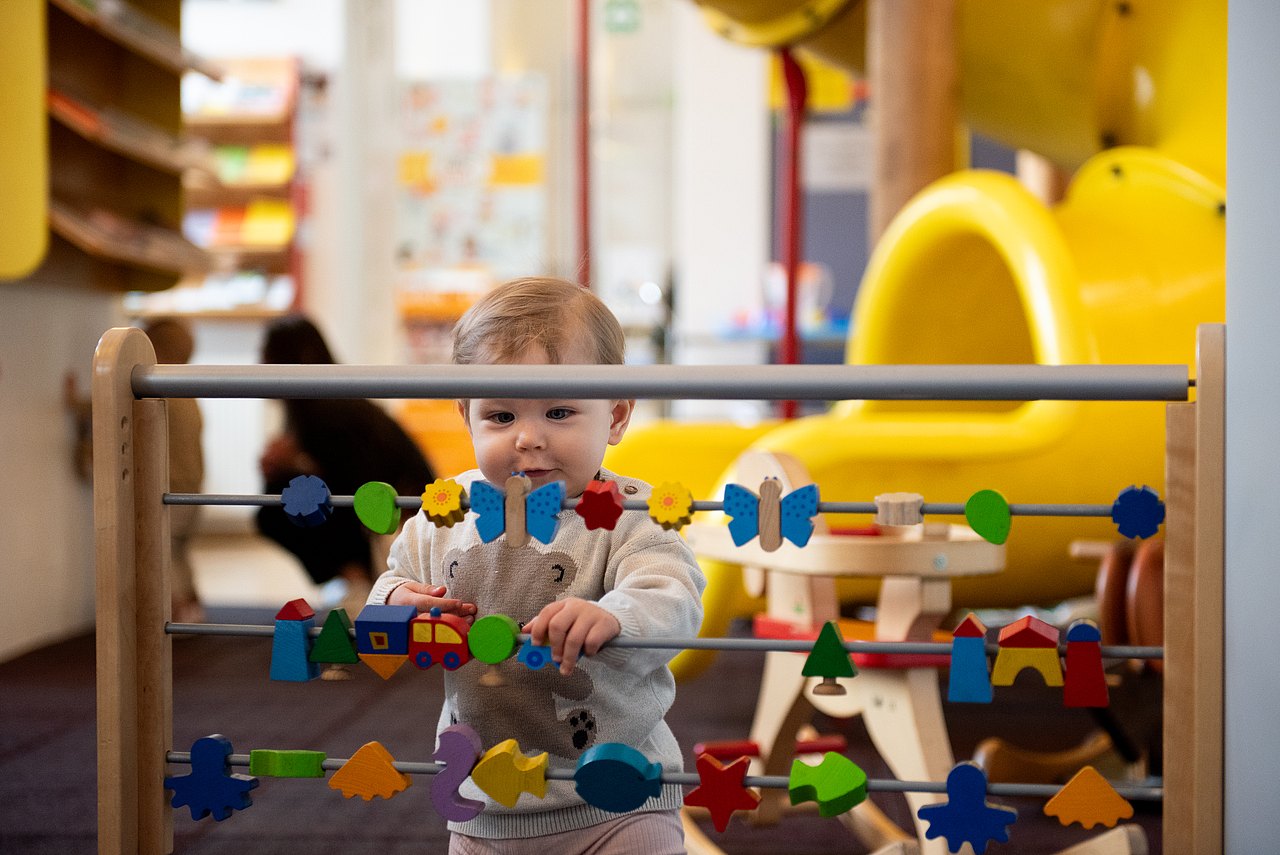Kind spielt bei Spielwand