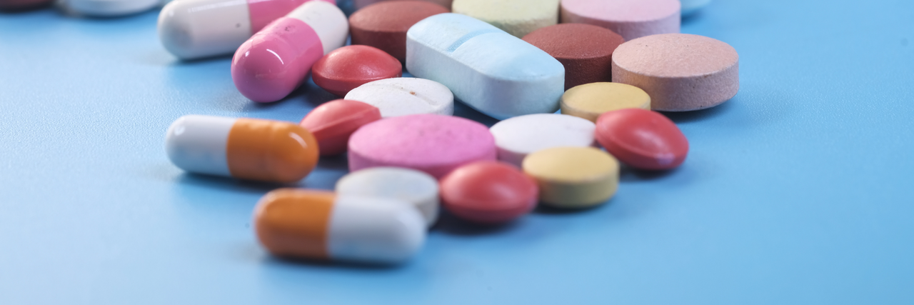 Unterschiedliche Pillen liegen vor einem blauen Hintergrund