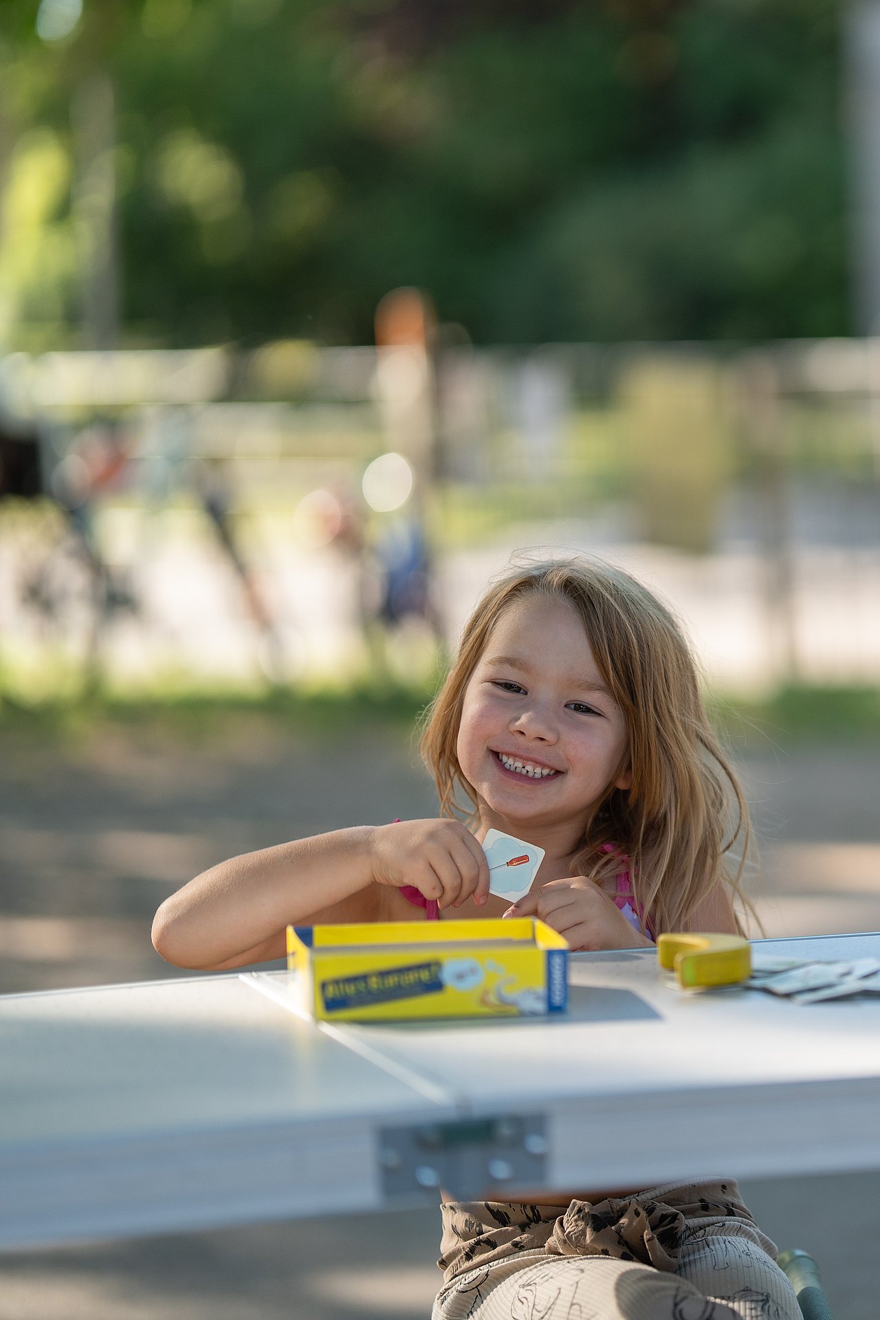 Kind mit Spiel sitzt am Tisch