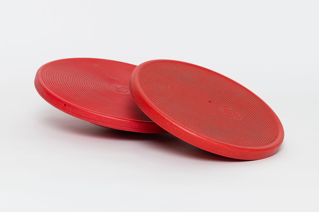 Rote Plastikscheibe mit Wölbung um Gleichgewicht zu halten.