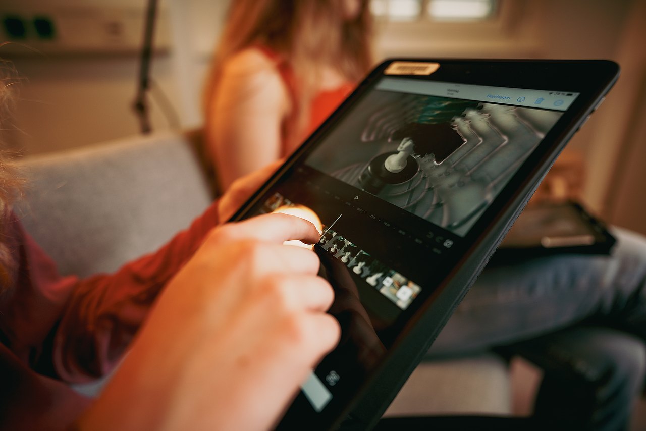 MZ_23_KRENN_v1-159 Ein Jugendlicher schneidet ein Video auf einem iPad.