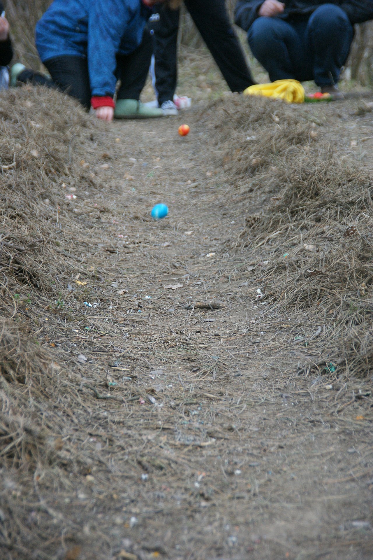Eine Erd-Piste, wo bunte Eier hinabrollen und hüpfen.