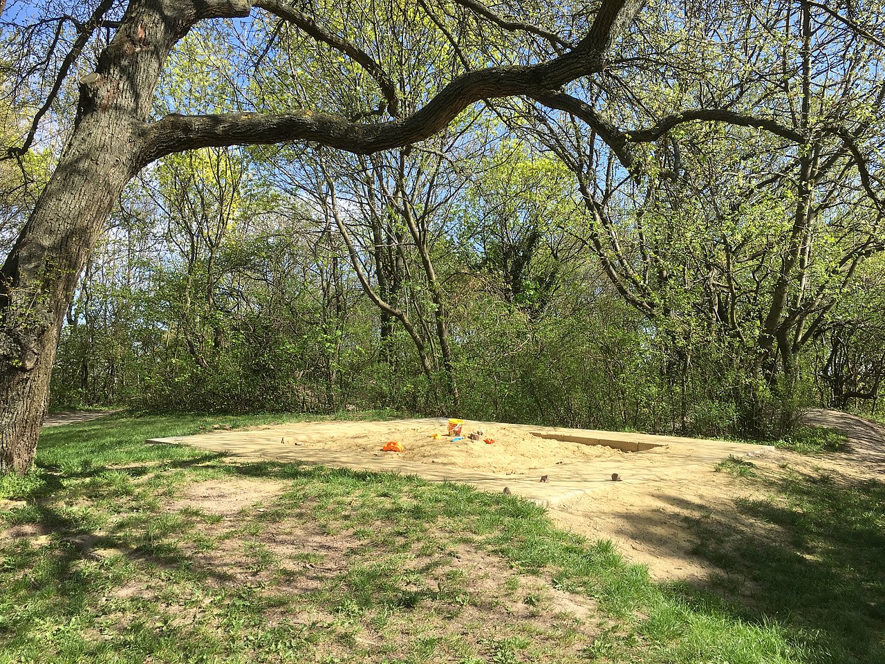 Sandspielbereich am Roten Berg West Sandspielbereich auf der Wiese unter einer Weide