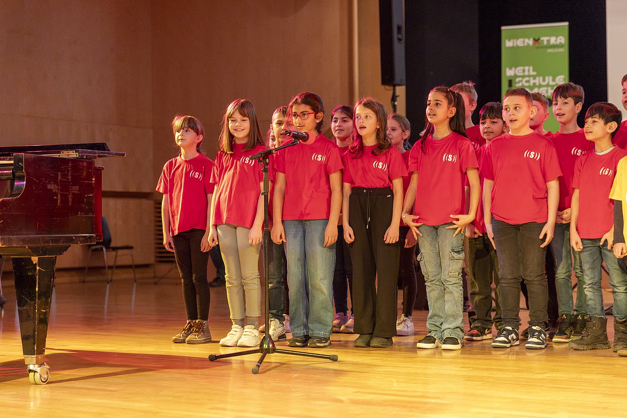 Kinderchor singt neben Flügel