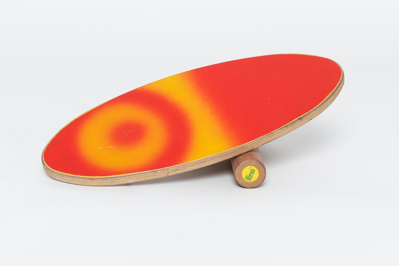 Ovale Holzplatte die auf einer Rolle balanciert werden soll.