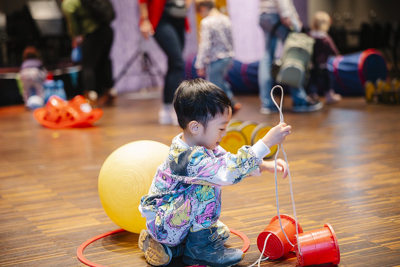 Kleiner Junge spielt mit Laufstelzen