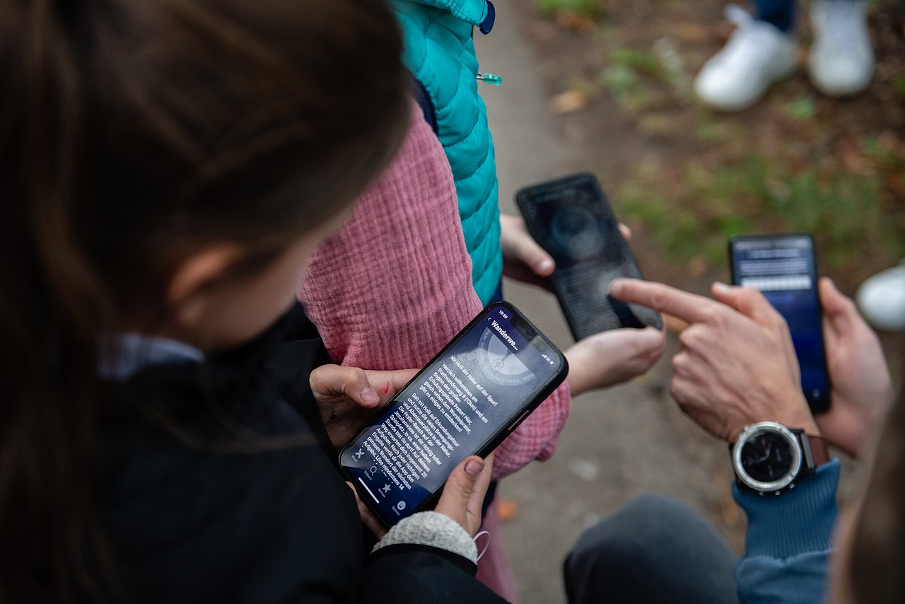 Kinder mit Smartphone in herbstlicher Natur