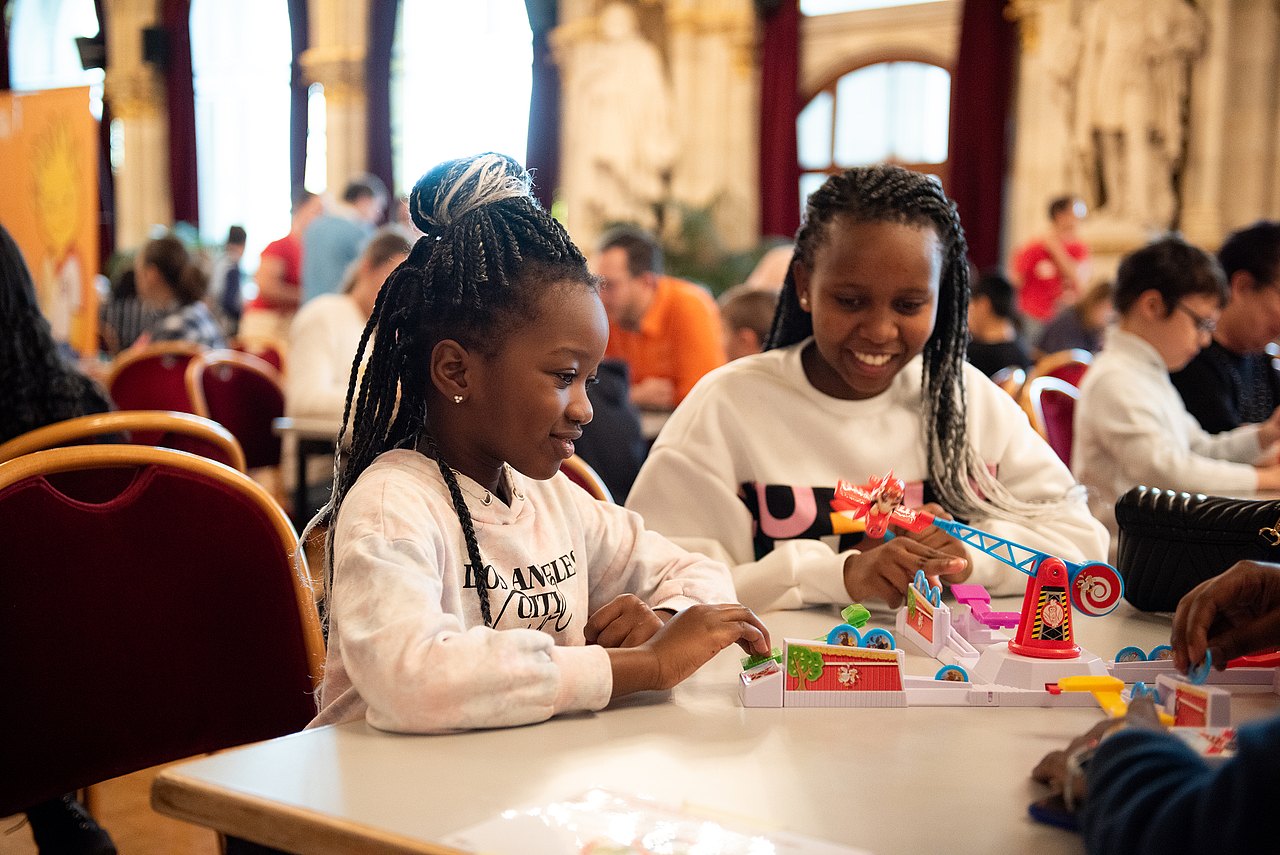 2 Kinder an einem Tisch spielen ein Brettspiel