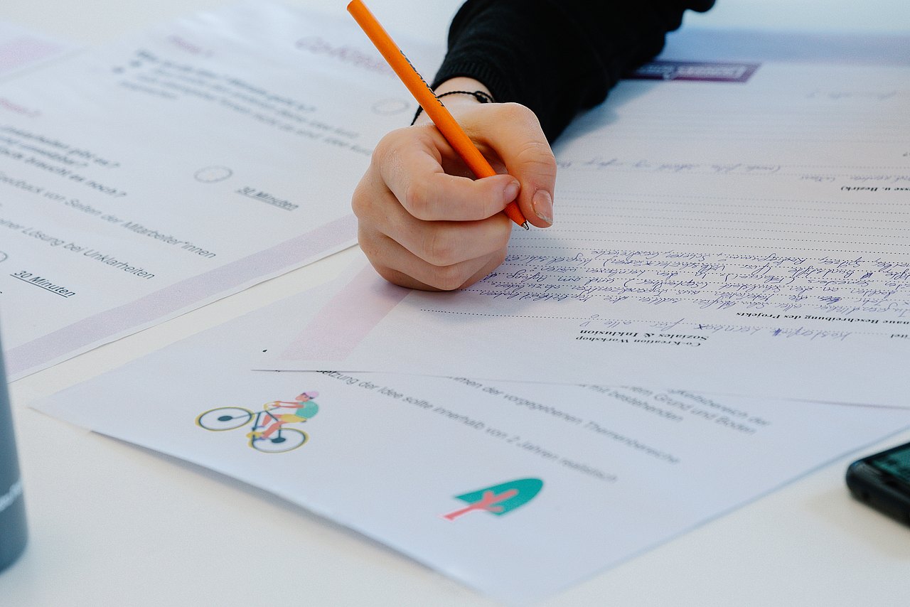 Kind schreibt auf einem Zettel