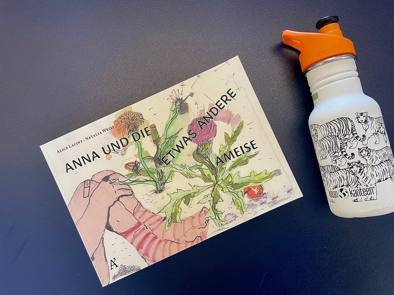 Kinderbuch auf dem man die Füße eines Kindes mit Ringelsocken sieht und Pflanzen 