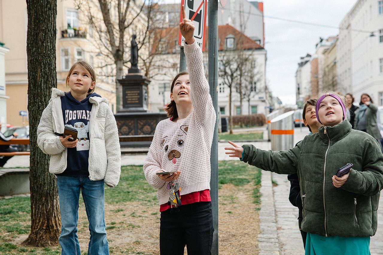 Kinder suchen beim Geocaching in der Stadt nach Hinweisen